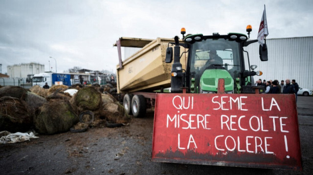 Agriculteurs bloquant l'accès d'une raffinerie pour protester contre l'augmentation des prix du pétrole à Lespinasse, près de Toulouse, le 17 février 2022. Le panneau indique "qui sème la pauvreté, récolte la colère".

