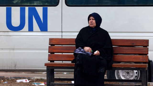 Une femme palestinienne déplacée est assise sur un banc en attendant à l'extérieur d'une clinique de l'Agence des Nations Unies pour les réfugiés de Palestine (UNRWA) à Rafah, dans le sud de la bande de Gaza, le 28 janvier 2024.