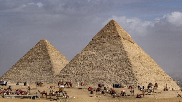 Dans cette photo prise le 6 février 2023, des guides de chameaux attendent avec leurs animaux près des Pyramides à la nécropole des pyramides de Gizeh, en périphérie de la capitale égyptienne. 