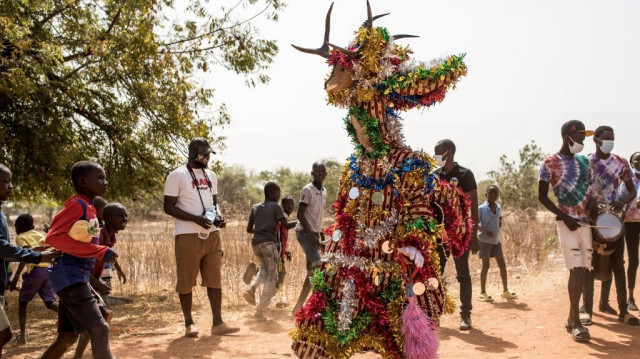 Une fête masquée de fées danse au son des tambours dans les rues lors du Festival de Kankurang à Janjanbureh le 27 janvier 2024. 