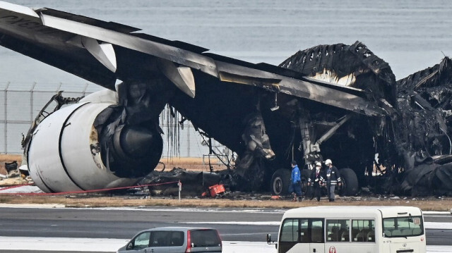 Les autorités examinent les débris brûlés d'un avion de ligne de la Japan Airlines (JAL) sur le tarmac de l'aéroport international de Tokyo à Haneda à Tokyo le 3 janvier 2024.