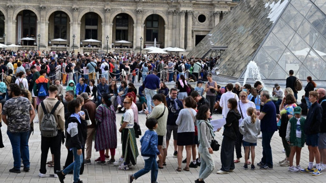 Les visiteurs font la queue pour entrer au musée du Louvre à Paris, le 9 août 2023.