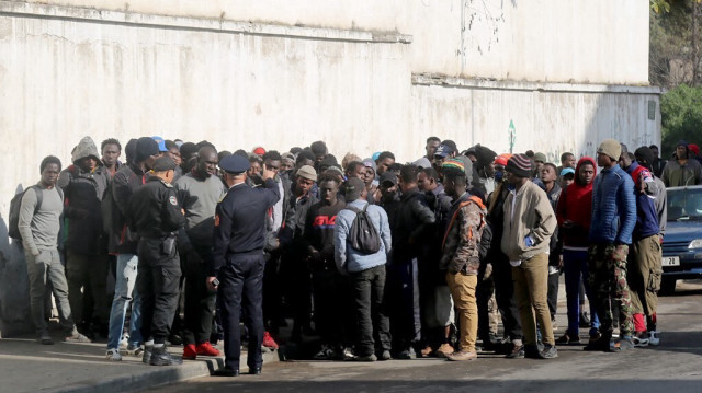 Un policier marocain s'entretient avec un groupe de migrants africains à Casablanca le 15 janvier 2023.