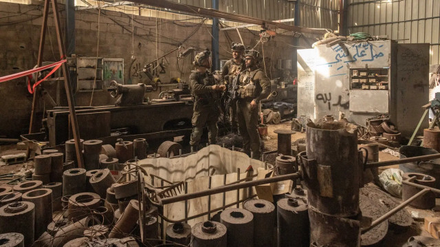 Израильские солдаты стоят на том, что, по их словам, является ракетным заводом, который был сфотографирован в январе во время экскурсии военных для международных журналистов в центральной части сектора Газа.