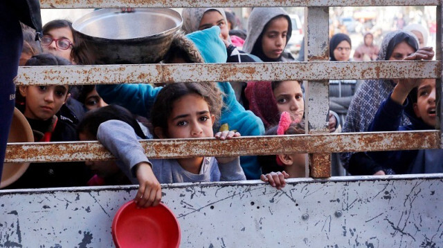 Des Palestiniens, dont des enfants, luttant contre la famine, attendent devant le stand d'aide alimentaire pour recevoir de la nourriture à Gaza, le 28 janvier 2024.