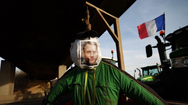 Un mannequin à l'effigie du président français, Emmanuel Macron suspendu aux côtés de tracteurs lors d'un blocage de l'autoroute A6 près de Villabe, au sud de Paris, le 29 janvier 2024.