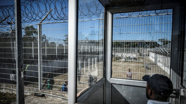 Un policier français surveille des hommes dans la cour du "Centre de rétention administrative" (CRA), un centre de rétention pour migrants à Vincennes, dans l'est de Paris, le 18 septembre 2019. (Archives)