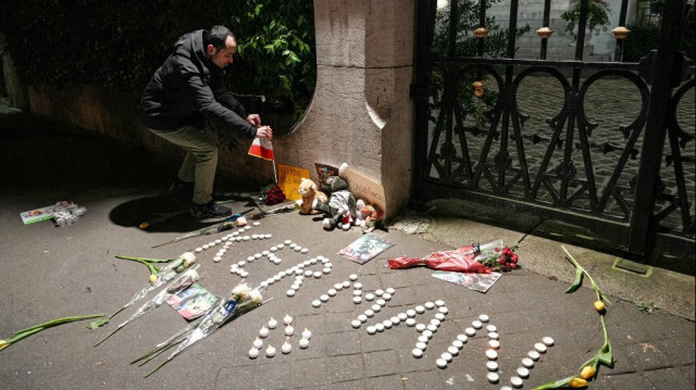 Un homme brandit un drapeau iranien lors d'un rassemblement en hommage aux victimes de l'attaque du 2 janvier, devant l'ambassade iranienne à Paris le 4 janvier 2024.