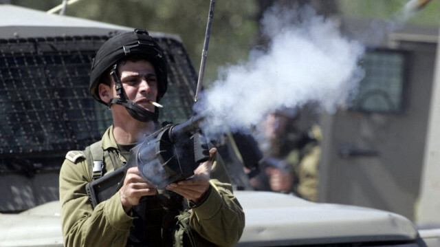 Un soldat de l'armée d'occupation israélienne en train de tirer des gaz lacrymogènes sur des Palestiniens dans le village de Budrus, à l'extérieur de la ville de Ramallah, le 30 mars 2010. 