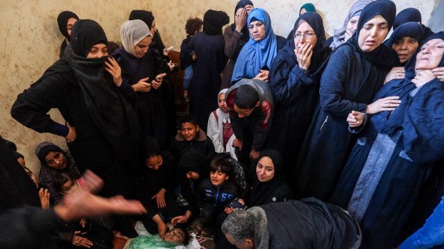 Des personnes pleurant les corps enveloppés d'enfants tués lors de bombardements israéliens à l'hôpital al-Najjar de Rafah, dans le sud de la bande de Gaza, le 5 janvier 2024.