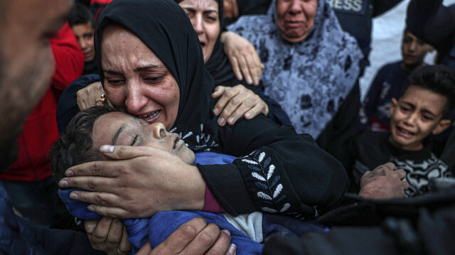 La tante de Mohamed Awad, 12 ans, qui a été tué avec sa famille immédiate lors d'un bombardement israélien, pleure en tenant son corps à l'hôpital européen de Khan Yunis, dans le sud de la bande de Gaza, le 6 janvier 2024.