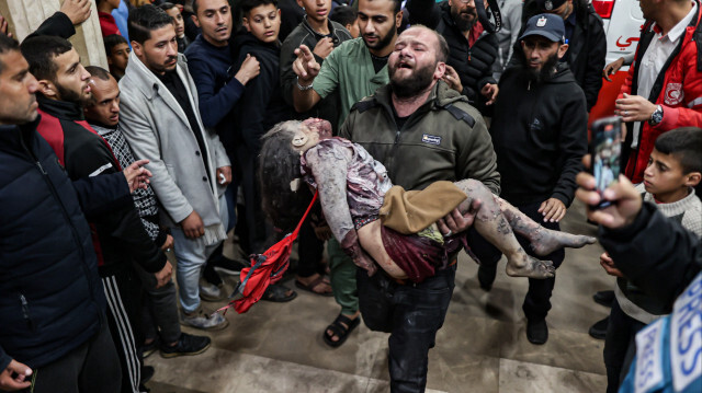 Un Palestinien porte le corps d'un enfant à l'hôpital al-Nasr après une attaque israélienne à Khan Yunis, Gaza, le 6 janvier 2024.