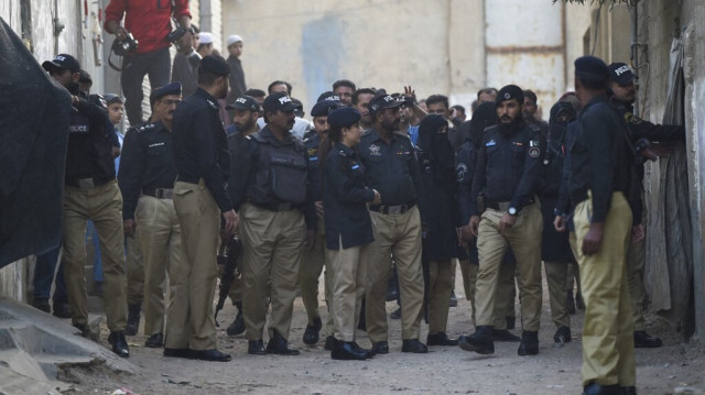 Le personnel de police frappe à la porte des réfugiés afghans lors d'une opération de recherche visant à identifier les immigrants illégaux présumés, en périphérie de Karachi le 17 novembre 2023. 