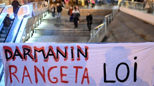 Une banderole sur laquelle on peut lire "Darmanin range ta loi" est brandie lors d'une manifestation contre la nouvelle loi française sur l'immigration, à Rennes, dans l'ouest de la France, le 20 décembre 2023.