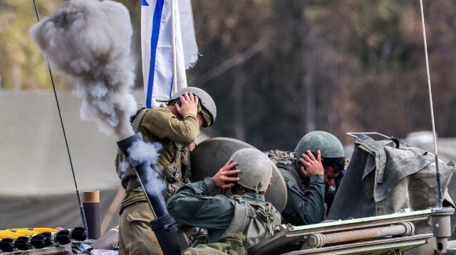 Des soldats israéliens se couvrent les oreilles lors d'un tir de mortier depuis un véhicule blindé situé le long de la frontière dans le sud de l'entité sioniste, le 3 janvier 2024.