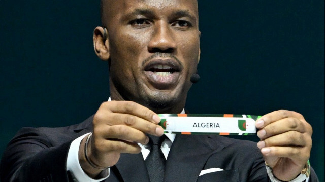 L'ancien footballeur ivoirien Didier Drogba montre le papier tiré au sort pour l'Algérie lors du tirage au sort officiel de la Coupe d'Afrique des Nations (CAN) 2024 au Parc des Expositions à Abidjan, le 12 octobre 2023.