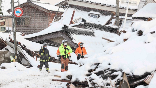 Le 8 janvier 2024, les pompiers à la recherche de personnes disparues alors que la neige couvre des parties de la zone touchée par la catastrophe dans la ville de Suzu, dans la préfecture d'Ishikawa, une semaine après qu'un tremblement de terre majeur de magnitude 7,5 a frappé la région de Noto dans la préfecture d'Ishikawa au Japon, le jour de l'An.