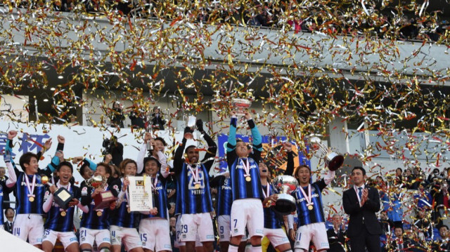 Le capitaine et milieu de terrain de Gamba Osaka, Yasuhito Endo, brandit le trophée de la Coupe de l'Empereur avec ses coéquipiers sur le podium du 95e tournoi de football de la Coupe de l'Empereur à Tokyo le 1er janvier 2016. 