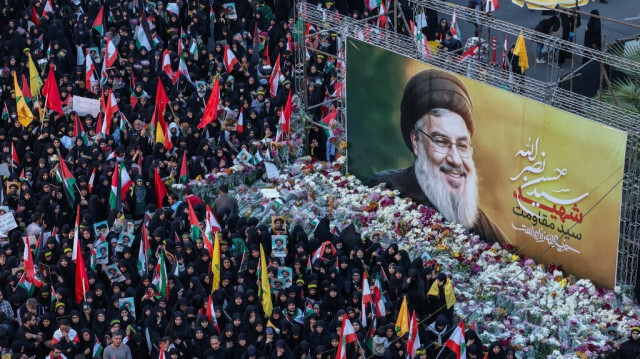 Des Iraniens déposent des fleurs sous une affiche représentant le leader du Hezbollah, Hassan Nasrallah, tué lors d'une frappe aérienne israélienne sur les banlieues sud de Beyrouth le 27 septembre, lors d'une manifestation anti-Israël sur la place de la Palestine à Téhéran le 30 septembre 2024.