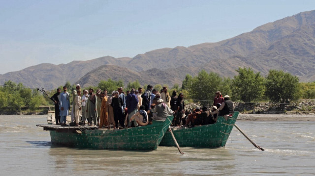 Des habitants montent sur des bateaux pour traverser une rivière dans le district de Kuz Kunar de la province de Nangarhar, le 1er octobre 2024.