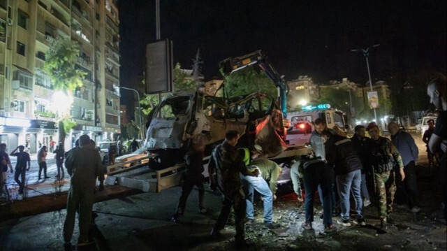 Les forces de sécurité syriennes enlèvent un véhicule endommagé à l'aide d'une grue dans le quartier de Mezzeh, à l'est de Damas, suite aux frappes aériennes israéliennes en Syrie, le 01 octobre 2024. 