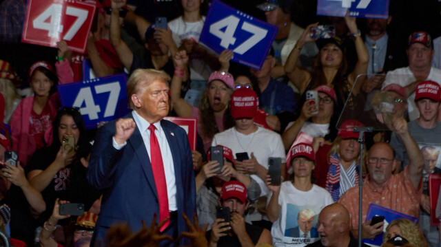 L'ancien président des États-Unis et candidat républicain à l'élection présidentielle Donald Trump serre le poing en quittant les lieux après avoir pris la parole lors d'un meeting de campagne au Grand Sierra Resort à Reno, dans le Nevada, le 11 octobre 2024.