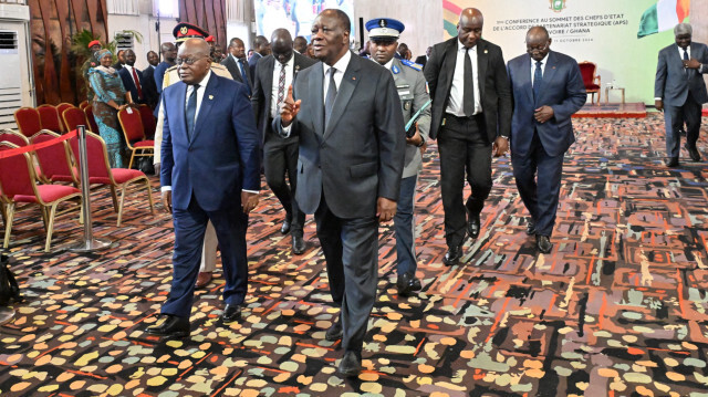 Le président ghanéen Nana Akufo-Addo (G) marche à côté du président ivoirien Alassane Ouattara (D) au palais présidentiel d'Abidjan lors du 1er sommet des chefs d'État de l'Accord de partenariat stratégique (APS) entre la Côte d'Ivoire et le Ghana, le 11 octobre 2024.