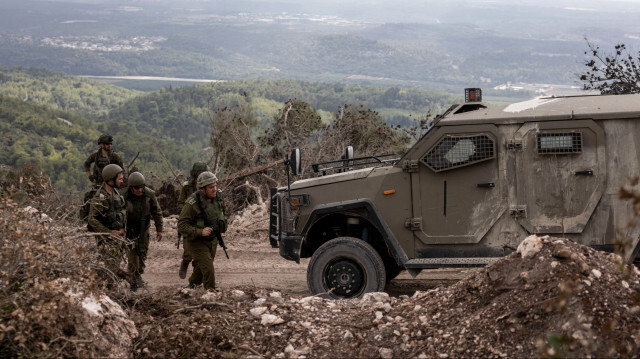 Cette photo prise le 13 octobre 2024 lors d'une opération de contrôle organisée par l'armée israélienne montre des troupes israéliennes patrouillant dans la région de Naqoura, au sud du Liban, près de la frontière. Les Casques bleus de l'ONU au Liban ont déclaré que des chars israéliens avaient franchi une porte pour entrer dans une position des Casques bleus au Liban le 13 octobre, après avoir bloqué leur mouvement le jour précédent.