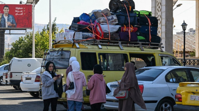 Des voyageurs arrivant du Liban marchent au poste frontière de Jdeidat Yabus, dans le sud-ouest de la Syrie, le 7 octobre 2024. 