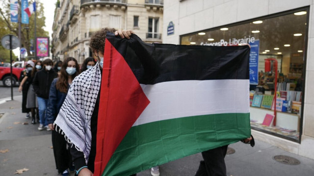 Des étudiants de l'Institut d'études politiques (Sciences Po Paris) marchent dans la rue en tenant un drapeau palestinien pour manifester contre la guerre d'Israël dans la bande de Gaza, à Paris, le 8 octobre 2024. 