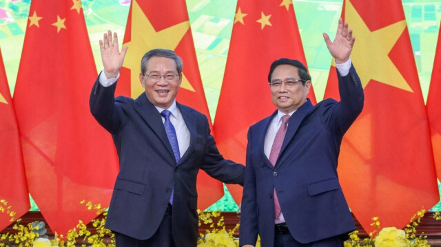 Le Premier ministre vietnamien Pham Minh Chinh (à droite) et le Premier ministre chinois Li Qiang (à gauche) se saluent en posant pour une photo lors d'une réunion au bureau du gouvernement à Hanoi, le 13 octobre 2024.