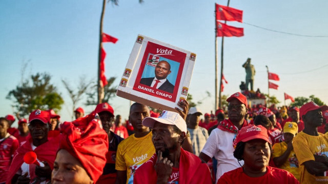 Des partisans du Front de libération du Mozambique (FRELIMO) tiennent des pancartes lors d'un rassemblement à Beira le 6 octobre 2024.