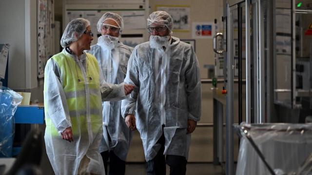 Le ministre français de l'Économie Antoine Armand avec des employés lors d'une visite au site de production de Doliprane dans l'industrie pharmaceutique Sanofi, à Lisieux, dans le nord de la France, le 14 octobre 2024.