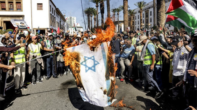 Des manifestants brûlent un drapeau israélien lors d'un rassemblement de solidarité avec les Palestiniens à Rabat, capitale du Maroc, le 6 octobre 2024, alors que le génocide perpétré par Israël contre les Palestiniens se poursuit dans la bande de Gaza.