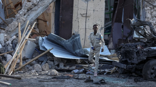 Un officier de police somalien observe les débris et la destruction d'un café à Mogadiscio le 15 juillet 2024 suite à l'explosion d'une voiture piégée où cinq personnes ont été tuées alors que des fans de football regardaient la finale de l'Euro 2024 à la fin du 14 juillet 2024. 