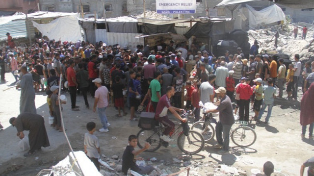 Des Palestiniens font la queue pour recevoir de la nourriture, distribuée par des organisations caritatives dans le camp de réfugiés de Jabalia dans la ville de Gaza.