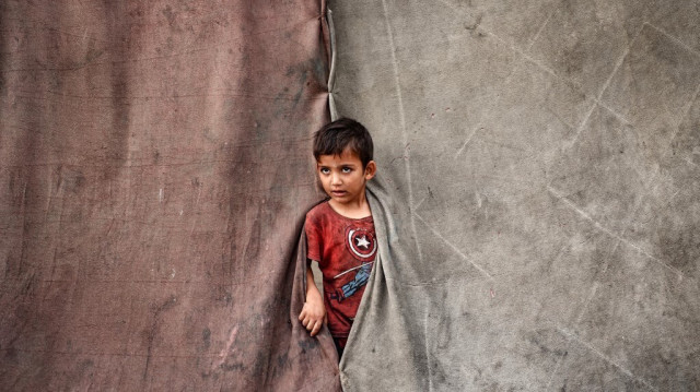 Un garçon palestinien regarde à l'intérieur d'une tente dans un camp de fortune pour les personnes déplacées à Deir al-Balah, dans le centre de la bande de Gaza, le 17 octobre 2024.