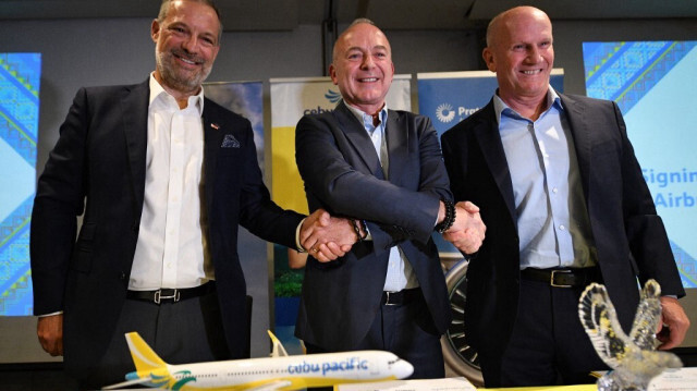 De gauche à droite: Benoit de Saint-Exupery, vice-président exécutif d'Airbus pour les ventes d'avions commerciaux, Michael Szucs, directeur général de Cebu Pacific, et Rick Deurloo, président de Pratt & Whitney pour les moteurs commerciaux, posent lors d'une cérémonie de signature à Manille le 2 octobre 2024.