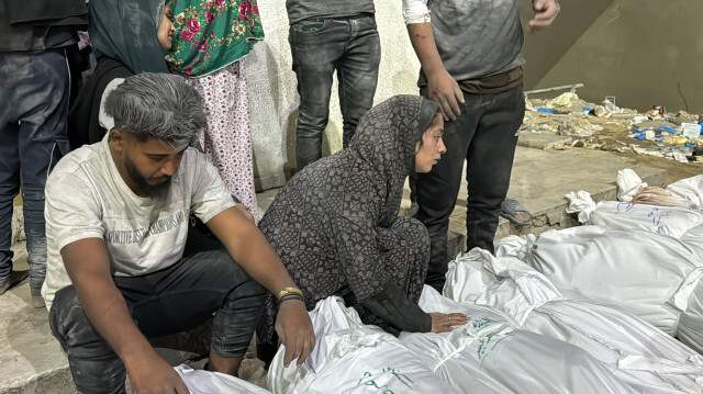 Des Palestiniens pleurent les corps couverts de membres de leur famille, tués lors d'une frappe aérienne israélienne, devant l'hôpital Kamal Adwan à Beit Lahia, dans le nord de la bande de Gaza, le 19 octobre 2024, dans le cadre du conflit actuel entre Israël et le groupe militant palestinien du Hamas.