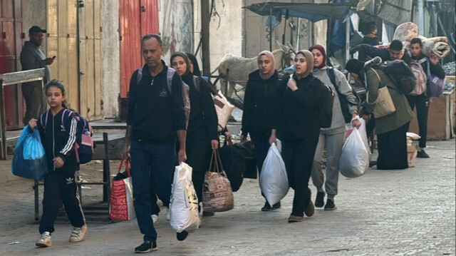 Des Palestiniens marchent dans une rue avec leurs affaires après avoir quitté leurs maisons à Beit Lahia, dans le nord de la Bande de Gaza, le 22 octobre 2024.