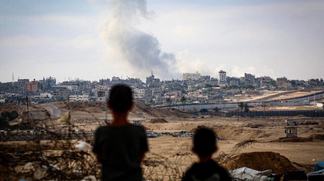 Des enfants Palestiniens observent la fumée épaisse qui se dégage des frappes de l'armée d'occupation israélienne à l'est de Rafah, dans le sud de la bande de Gaza, le 13 mai 2024.