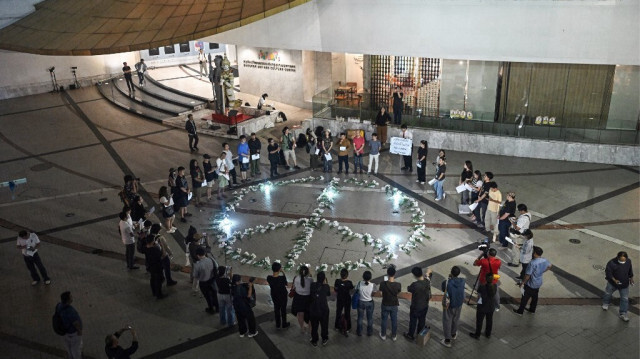 Des personnes se rassemblent autour d'un symbole de paix pour demander justice pour les victimes de l'incident d'octobre 2004 connu sous le nom de "massacre de Tak Bai", lorsque des dizaines de manifestants musulmans ont été asphyxiés dans des camions de l'armée, lors d'une manifestation à Bangkok le 15 octobre 2024.