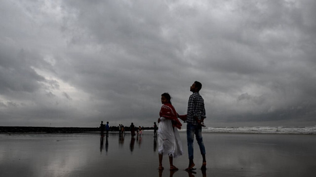 Des personnes se tiennent le long d'une plage près du golfe du Bengale à Digha, à environ 200 km au sud-ouest de Kolkata, le 24 octobre 2024, alors que le cyclone Dana devrait frapper les côtes des États indiens du Bengale occidental et de l'Odisha.