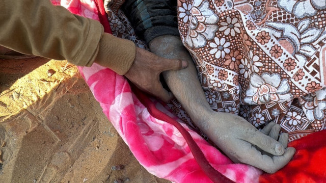 Un Palestinien prie sur le corps d'un parent, tué lors d'une frappe aérienne israélienne, à Beit Lahia, dans le nord de la bande de Gaza, le 27 octobre 2024.