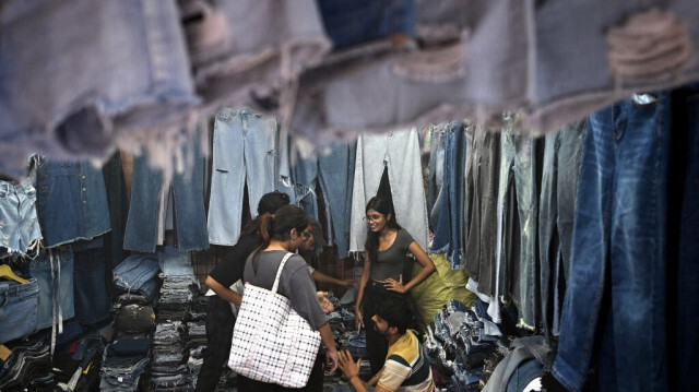 Des clients regardent des vêtements d'occasion dans une boutique d'un marché de New Delhi, le 28 septembre 2024.