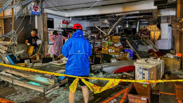 Le personnel d'un dépanneur nettoie les dégâts après l'arrivée du typhon Krathon à Kaohsiung, le 3 octobre 2024.