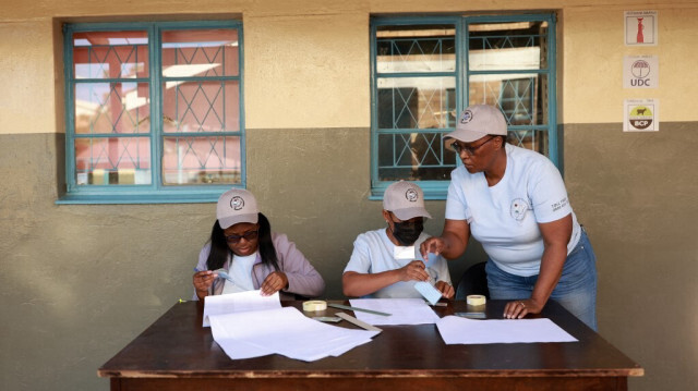 Des agents électoraux vérifient la liste des électeurs avant d'ouvrir les bureaux de vote de l'école primaire Itumeleng à Gaborone, le 30 octobre 2024, lors des élections générales au Botswana. 