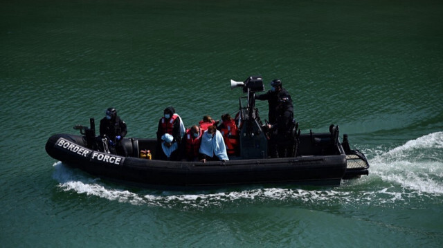 Des migrants à bord d'un canot pneumatique de la UK Border Force, après avoir été secourus en mer alors qu'ils tentaient de traverser la Manche et conduits à la marina de Douvres, située dans le sud-est de l'Angleterre, le 16 juin 2022.
