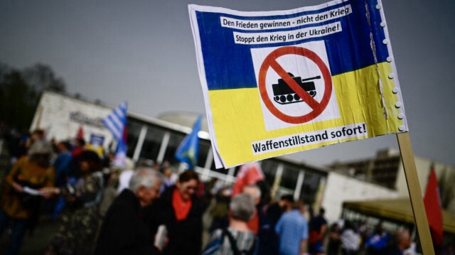 Des manifestant tiennent une pancarte sur laquelle on peut lire "Arrêtez la guerre en Ukraine ! - Cessez le feu maintenant !", lors d'une protestation le long de l'avenue Karl-Marx à Berlin, le 30 mars 2024.