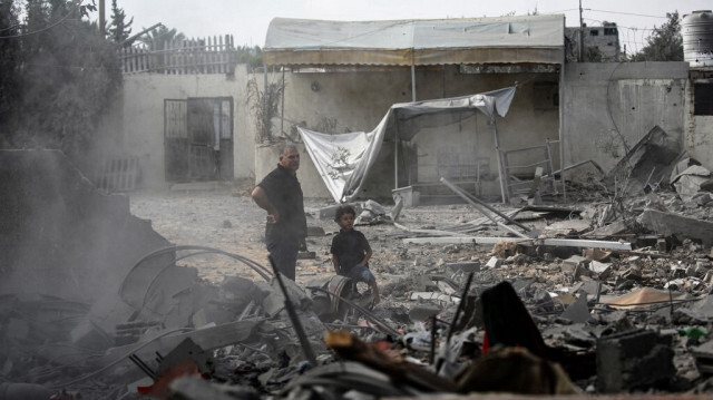 Un homme et un enfant regardent les décombres d'une maison touchée par une frappe israélienne à Deir El-Balah, dans le centre de la bande de Gaza, le 4 octobre 2024,